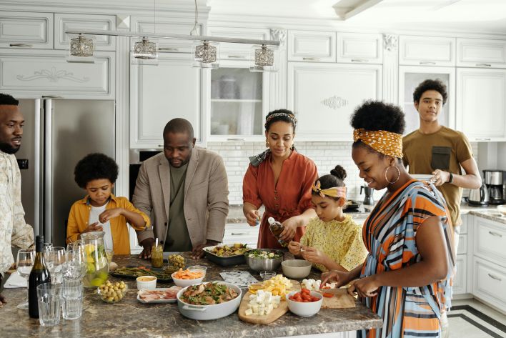 A happy family gathers in the kitchen to prepare a delicious meal together, fostering togetherness and joy.